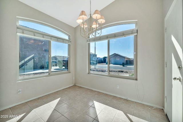 empty room with light tile patterned floors, vaulted ceiling, and an inviting chandelier