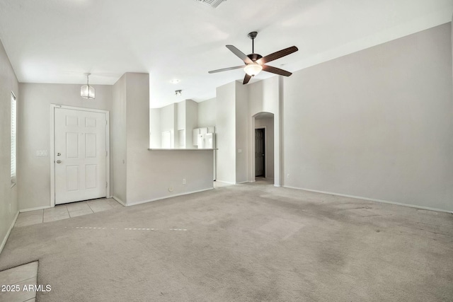 unfurnished living room with ceiling fan, lofted ceiling, and light carpet