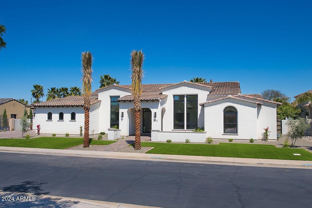 mediterranean / spanish home featuring a front lawn