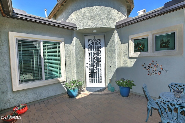 view of exterior entry with a patio