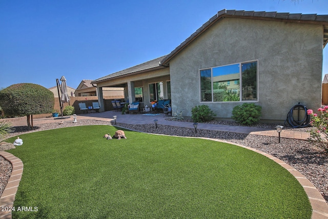 back of property featuring a lawn and a patio