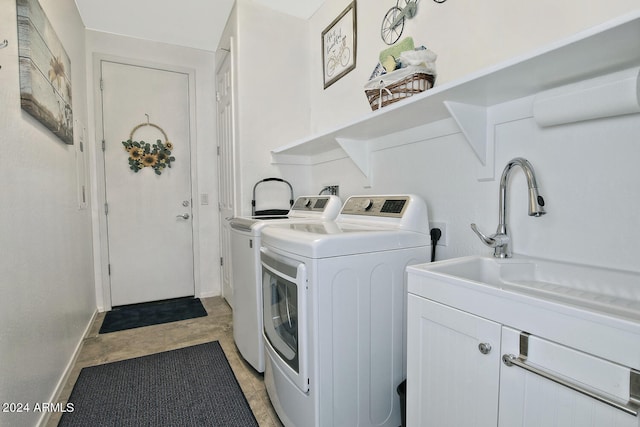 clothes washing area with washer and clothes dryer and cabinets