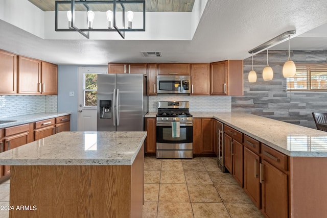kitchen featuring light tile patterned floors, stainless steel appliances, decorative backsplash, visible vents, and a peninsula