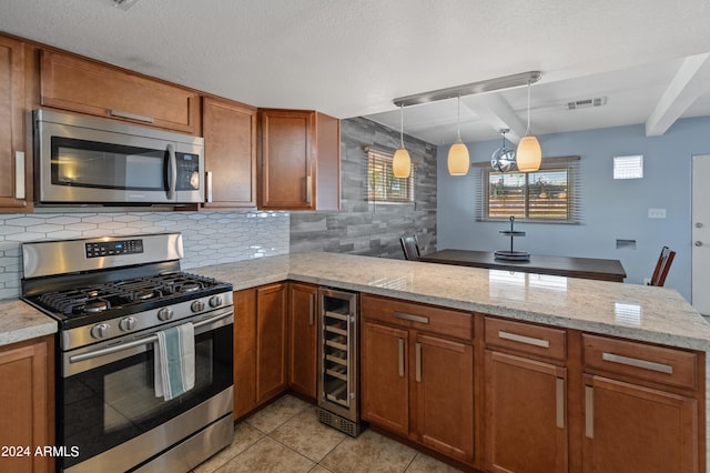 kitchen featuring appliances with stainless steel finishes, decorative backsplash, light tile patterned flooring, kitchen peninsula, and beverage cooler