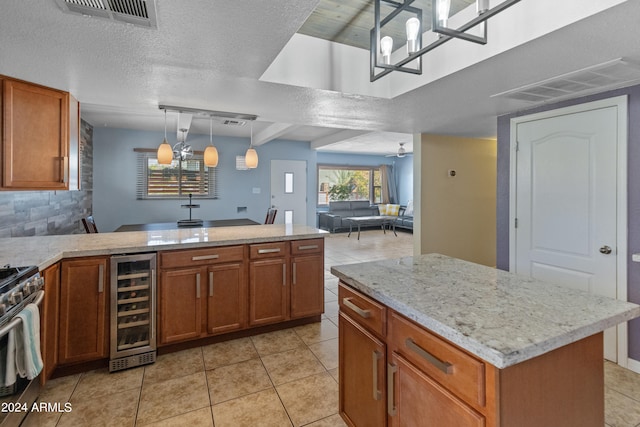 kitchen featuring light tile patterned floors, pendant lighting, a textured ceiling, beverage cooler, and a chandelier