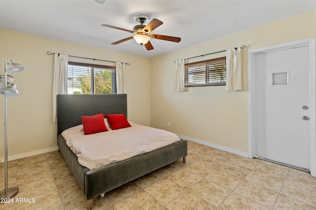 tiled bedroom featuring ceiling fan