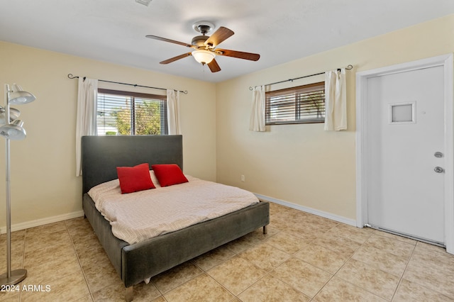 bedroom with a ceiling fan, light tile patterned floors, and baseboards
