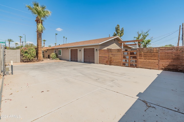 view of front of house featuring concrete driveway, a garage, and fence
