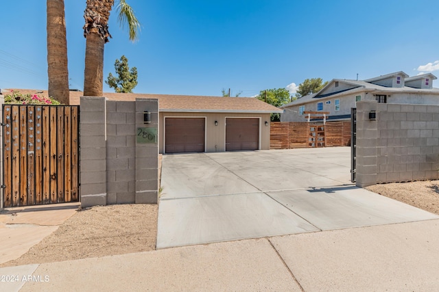 view of front facade with fence, driveway, a gate, and a garage