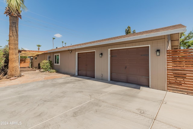 garage with driveway and fence