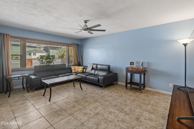 living room featuring ceiling fan, a textured ceiling, and light tile patterned flooring