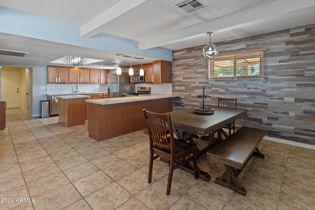 dining space featuring light tile patterned floors, tile walls, sink, and beamed ceiling