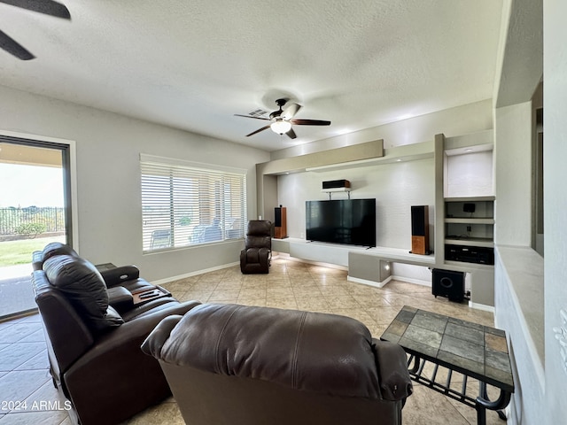 living room featuring ceiling fan, plenty of natural light, and a textured ceiling