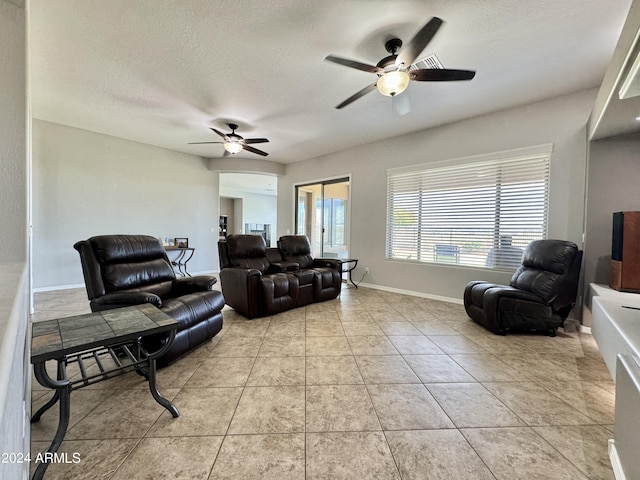 tiled living room with ceiling fan and a textured ceiling