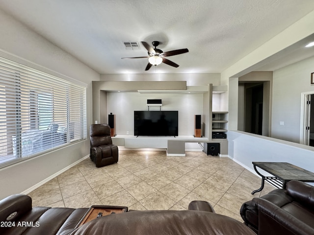 tiled living room with a textured ceiling and ceiling fan