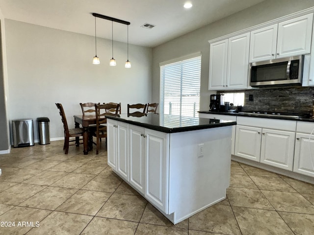 kitchen featuring white cabinets, backsplash, gas cooktop, and hanging light fixtures