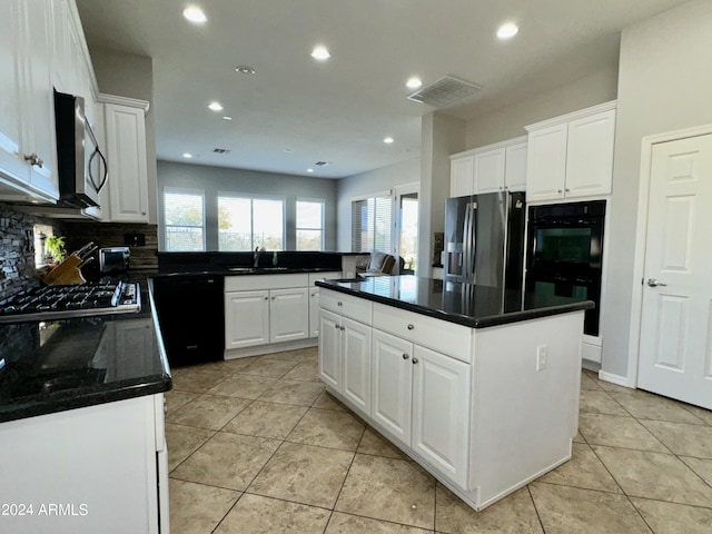 kitchen with white cabinetry, sink, light tile patterned floors, a kitchen island, and black appliances