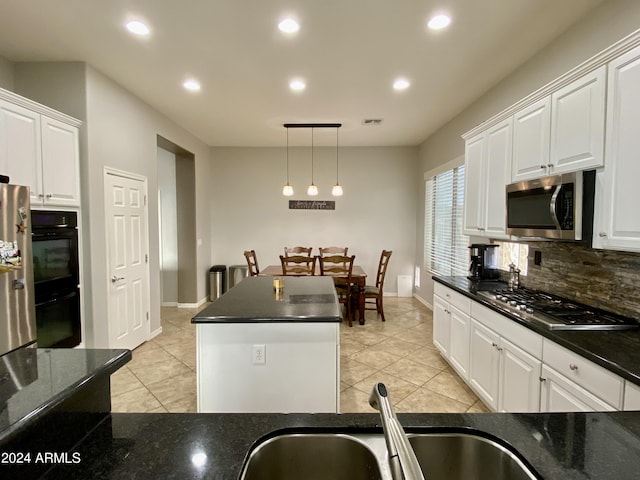 kitchen with white cabinetry, stainless steel appliances, pendant lighting, decorative backsplash, and light tile patterned floors