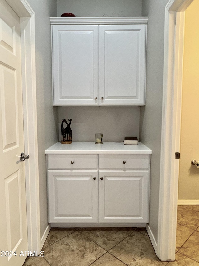 bar featuring white cabinets and light tile patterned floors