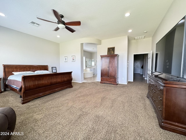 bedroom with light colored carpet, ensuite bath, and ceiling fan