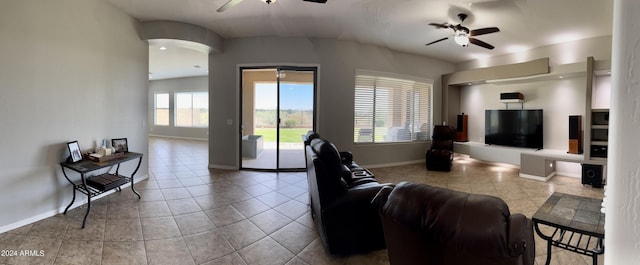 tiled living room with a wealth of natural light and ceiling fan