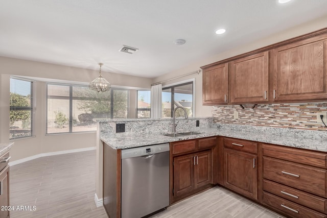 kitchen featuring backsplash, sink, stainless steel dishwasher, light stone counters, and a chandelier