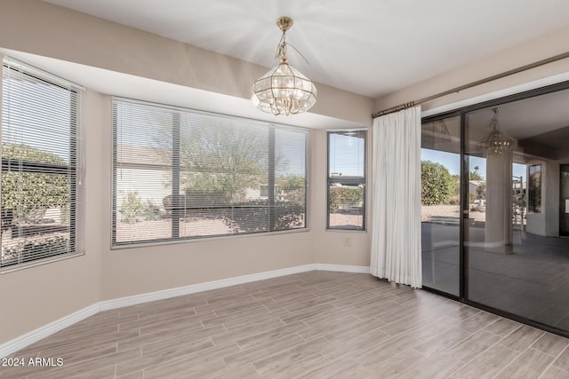 unfurnished sunroom featuring a chandelier and a healthy amount of sunlight