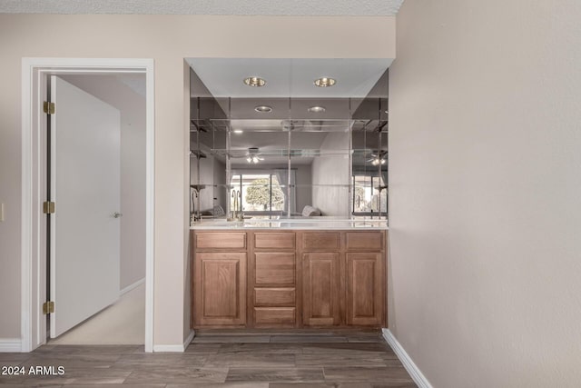 bar featuring a textured ceiling and hardwood / wood-style flooring