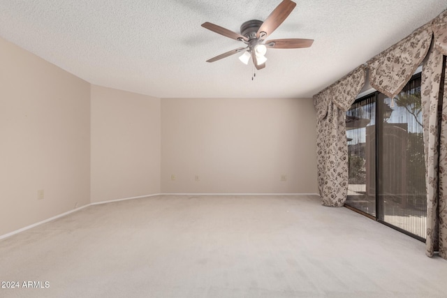 carpeted spare room featuring a textured ceiling and ceiling fan