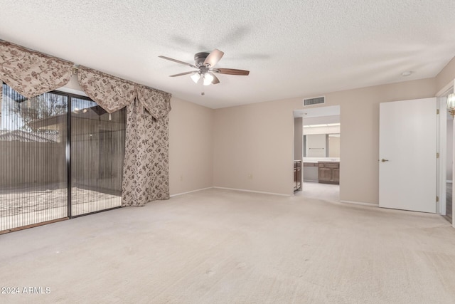 carpeted empty room featuring a textured ceiling and ceiling fan