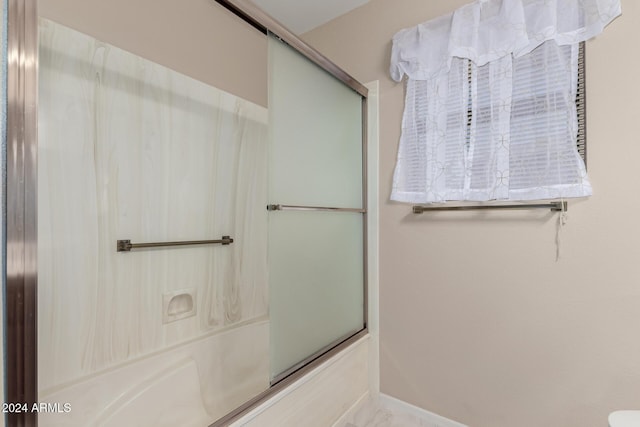 bathroom with combined bath / shower with glass door