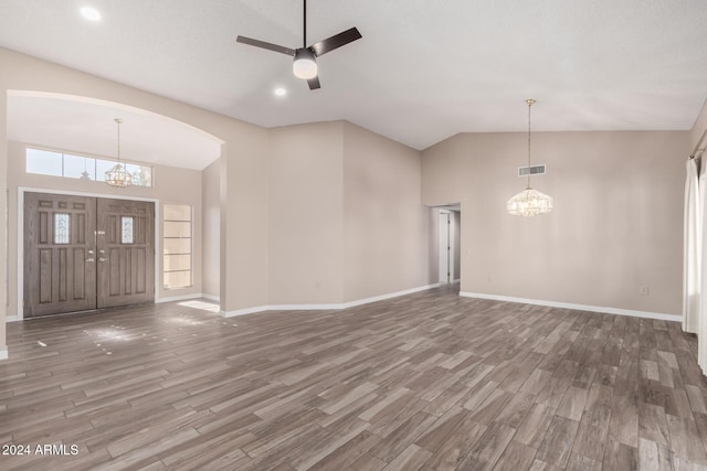 foyer with ceiling fan with notable chandelier, wood-type flooring, and high vaulted ceiling