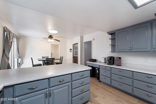 255 N Hunt Dr E, Mesa, AZ 85203 - kitchen featuring light wood-style floors, light countertops, a ceiling fan, and open shelves
