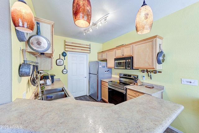 kitchen with light brown cabinetry, a sink, light countertops, a peninsula, and stainless steel appliances