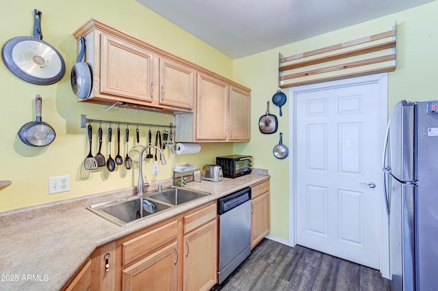 kitchen with a sink, dark wood-style flooring, appliances with stainless steel finishes, and light countertops