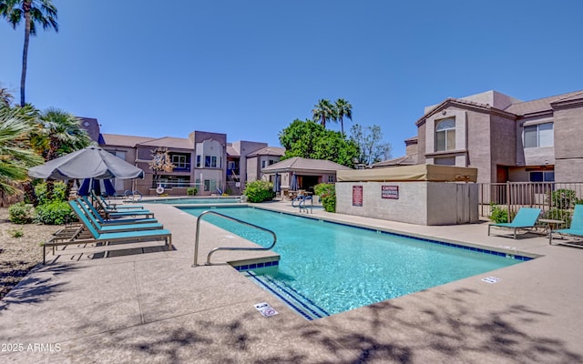 pool featuring fence, a gazebo, and a patio area