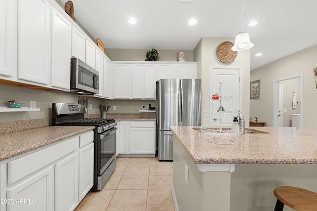 kitchen featuring light tile patterned floors, appliances with stainless steel finishes, and white cabinetry