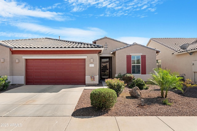 view of front of house with a garage, stucco siding, driveway, and a tile roof