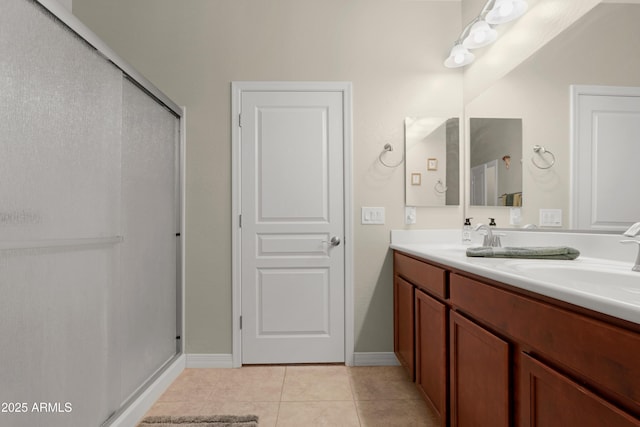 bathroom with a sink, tile patterned floors, a shower stall, and double vanity