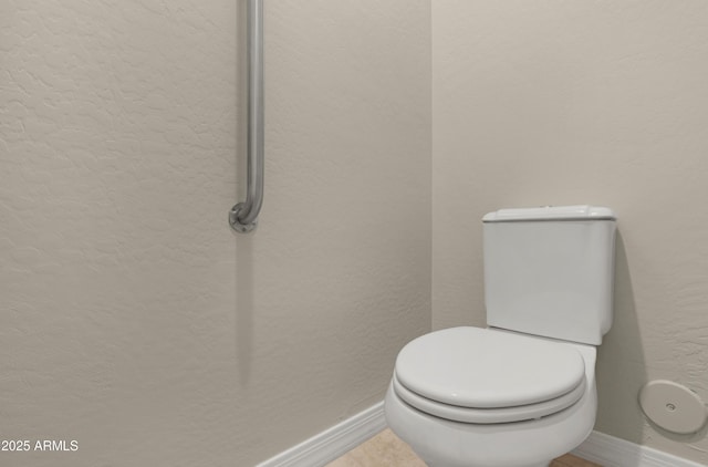 bathroom with toilet and baseboards