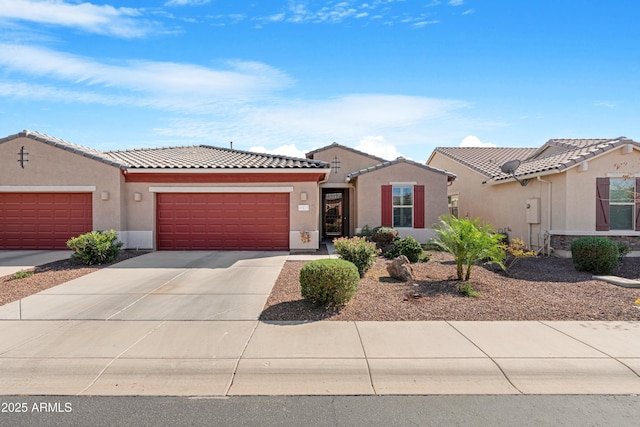 view of front of property with a garage, stucco siding, driveway, and a tiled roof