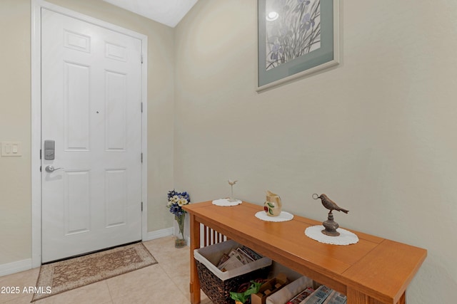foyer entrance featuring baseboards and light tile patterned floors