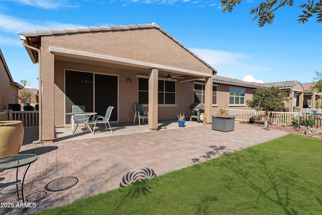 back of property featuring fence, stucco siding, a patio area, and ceiling fan