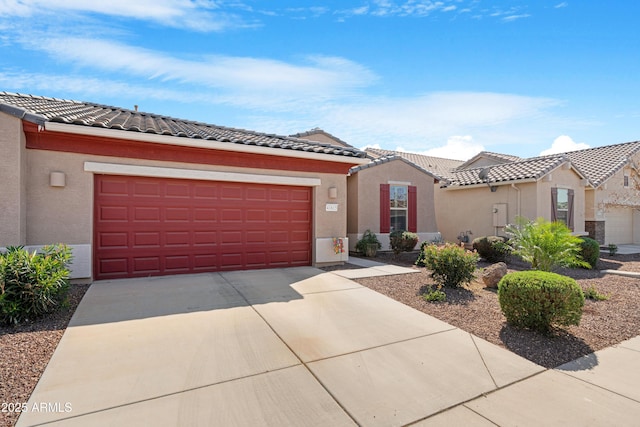 mediterranean / spanish-style house featuring an attached garage, stucco siding, a tile roof, and concrete driveway