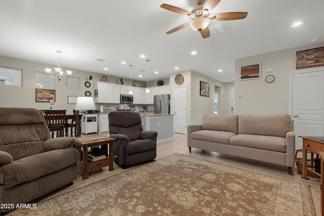 living area featuring recessed lighting, ceiling fan with notable chandelier, light tile patterned floors, and visible vents