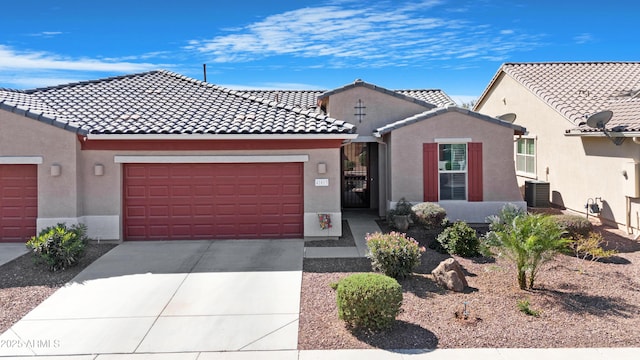 mediterranean / spanish-style house featuring a garage, stucco siding, driveway, and a tiled roof