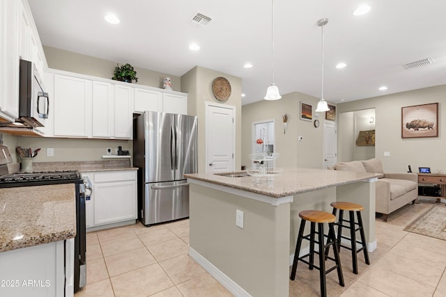 kitchen featuring stainless steel appliances, white cabinetry, light tile patterned flooring, and visible vents