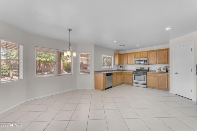 kitchen featuring a sink, appliances with stainless steel finishes, a notable chandelier, and light countertops