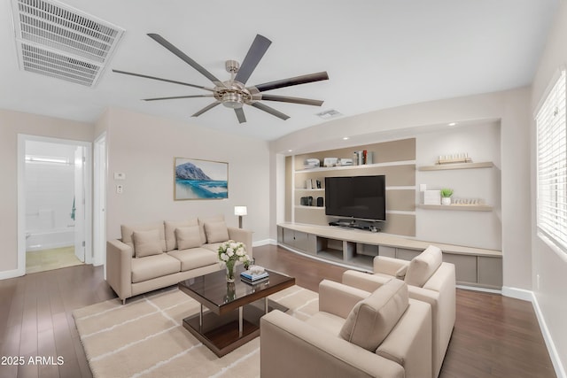 living area with visible vents, a ceiling fan, baseboards, and wood finished floors