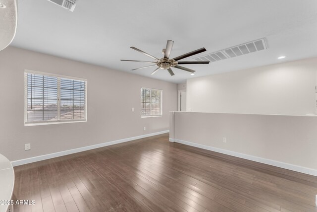 unfurnished room with baseboards, a ceiling fan, wood finished floors, and visible vents